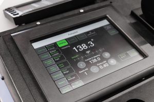 Industrial Catalog image by Seatronx Closeup of a marine touchscreen digitizer surface on a ship bridge navigation console, illustrating the procurement decision moment for a marine-grade sensor stack.