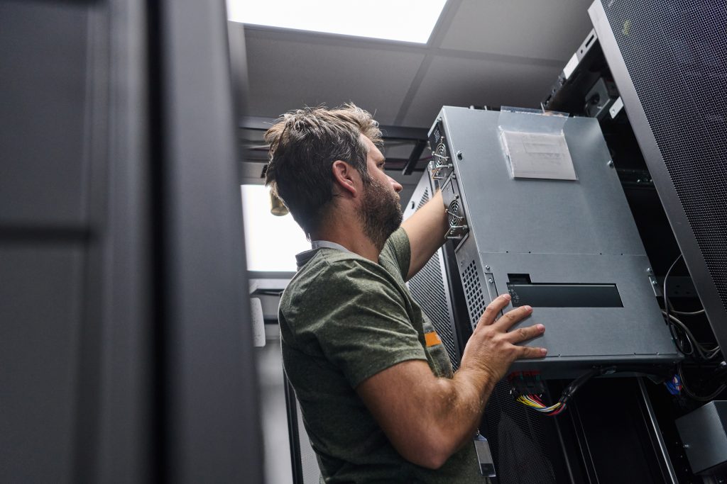SEAEM-I20A Rugged Tablet image by Seatronx IT technician installing a rugged server chassis into a marine equipment-room rack cabinet