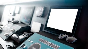 A captain wearing polarized sunglasses at a boat helm looking at a marine navigation display on the console, representing the polarized-lens readability decision for a helm screen.
