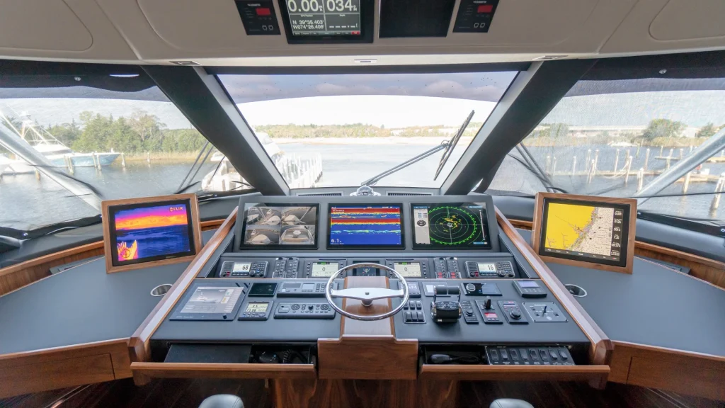 Military Catalog image by Seatronx Yacht helm with an integrated bank of marine electronics displays showing thermal camera, camera views, sonar, radar and chartplotter screens