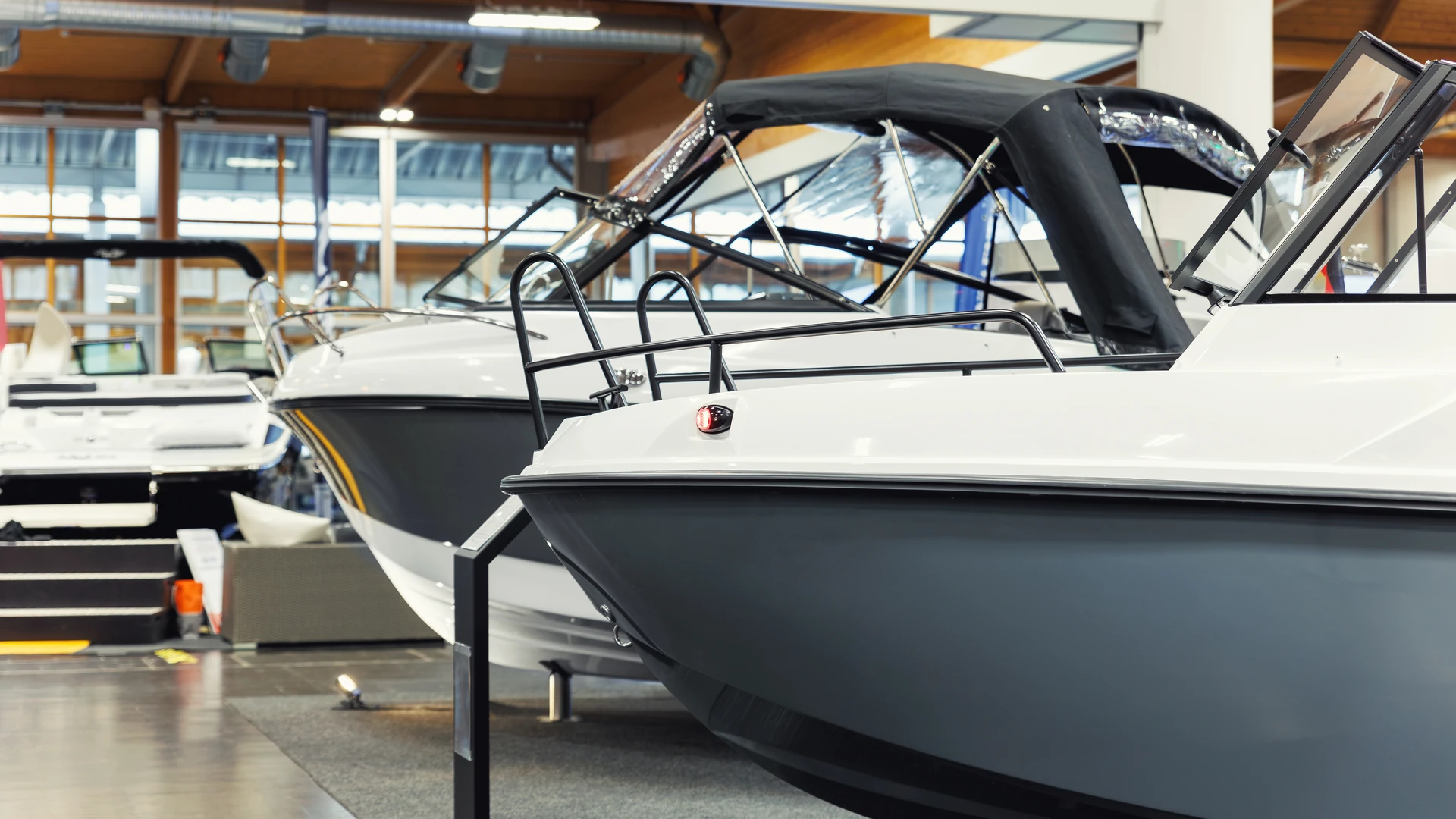 Powerboats on display stands in an indoor boat exhibition hall