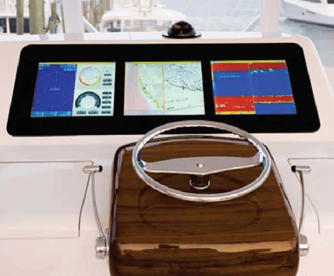 5 Marine Electronics Trends to Watch in 2027 image by Seatronx Seatronx Glass Pod bridge display with three screens showing navigation and engine data above a boat's steering wheel