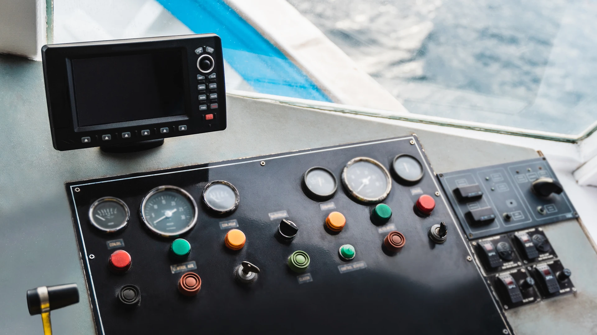 Compact display unit above a switch panel and gauges on a boat's helm console